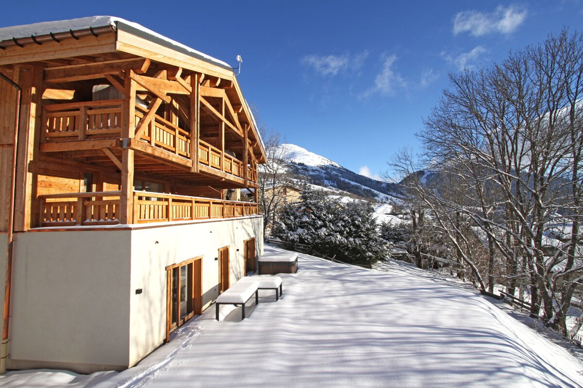 A snowy house with a mountain in the background