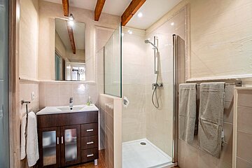 A bathroom with a sink and a walk in shower