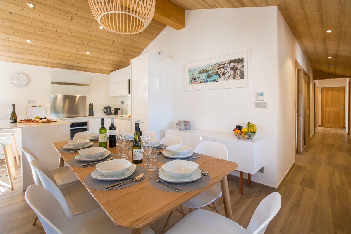 A dining room table with a bottle of wine on it
