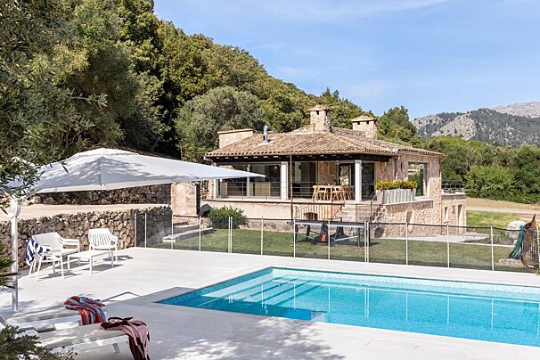 A large house with a swimming pool in front of it