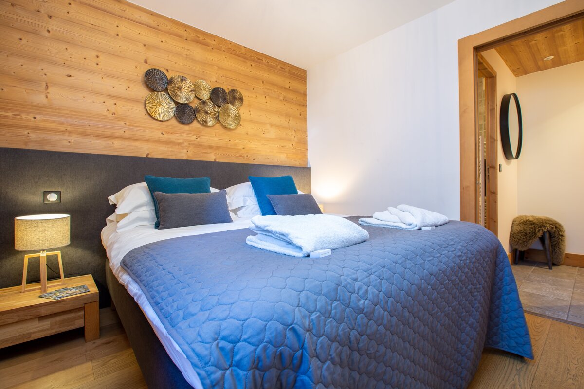A bedroom with a large bed and a lamp
