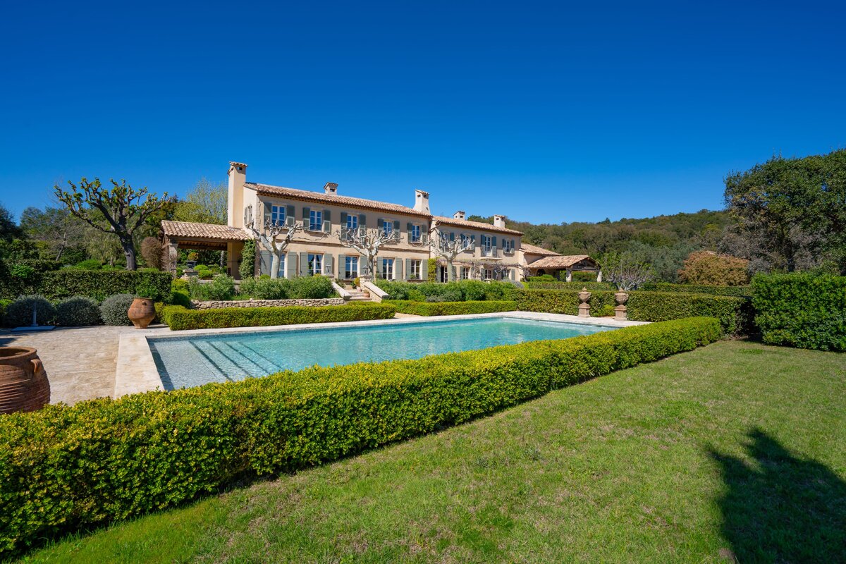 A large house with a swimming pool in front of it