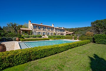 A large house with a swimming pool in front of it
