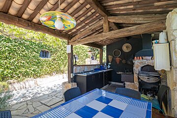 A blue and white checkered table under a wooden roof