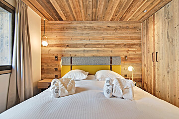A bedroom with a bed and a wooden wall