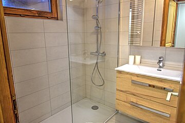 A bathroom with a walk in shower and a sink