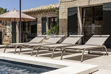 A row of lounge chairs next to a pool with a sign that says knight