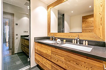 A bathroom with two sinks and a large mirror