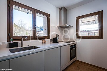 A kitchen with a sink and a window with the number 80 on it