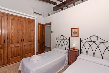 A bedroom with two beds and a picture on the wall