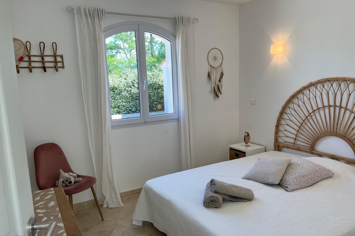 A bedroom with a bed and a dream catcher on the wall