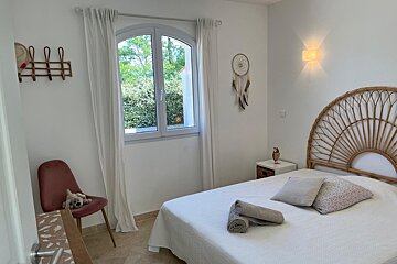 A bedroom with a bed and a dream catcher on the wall