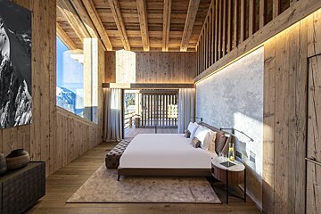 A bedroom with wooden walls and a large bed