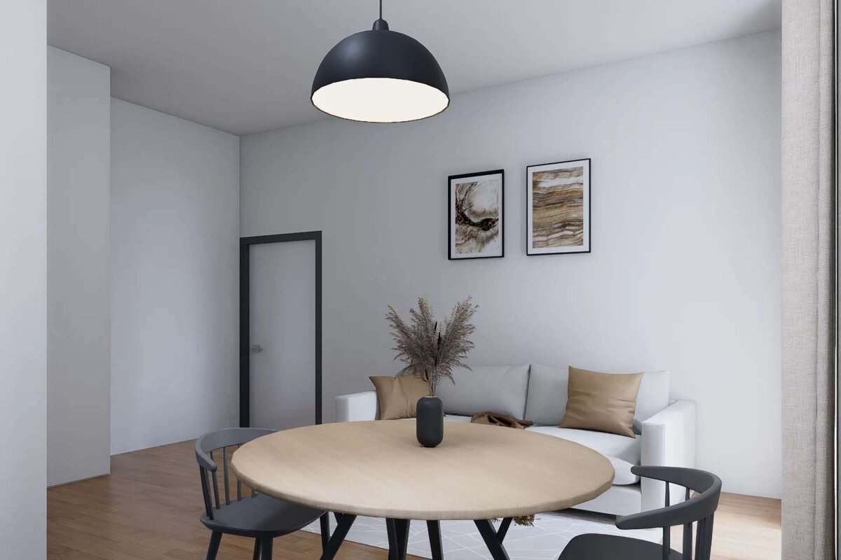 A modern room features a round dining table, grey chairs, white sofa, abstract wall art, and a black pendant light, all on hardwood floors.