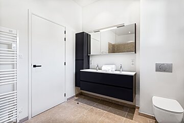 A bathroom with two sinks and a toilet