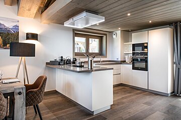 A kitchen with white cabinets and a stove top oven