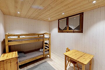 A bedroom with bunk beds and a wooden table
