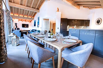 A dining room table with a bottle of wine on it