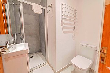 A bathroom with a toilet a sink and a shower