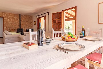 A bottle of wine sits on a table next to a book