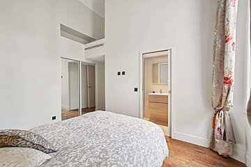 A bedroom with a bed and a door that leads to a bathroom
