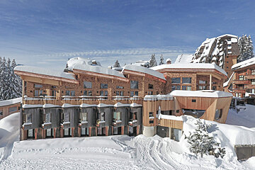 A large wooden building with snow on the roof