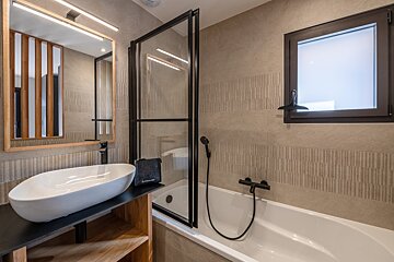A bathroom with a sink and a bathtub with a towel that says ' a ' on it