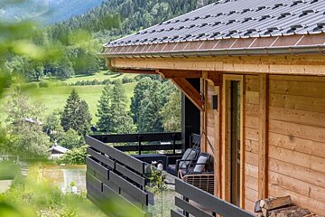 A wooden house with a balcony overlooking a valley