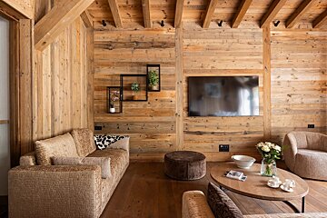 A living room with wooden walls and a flat screen tv