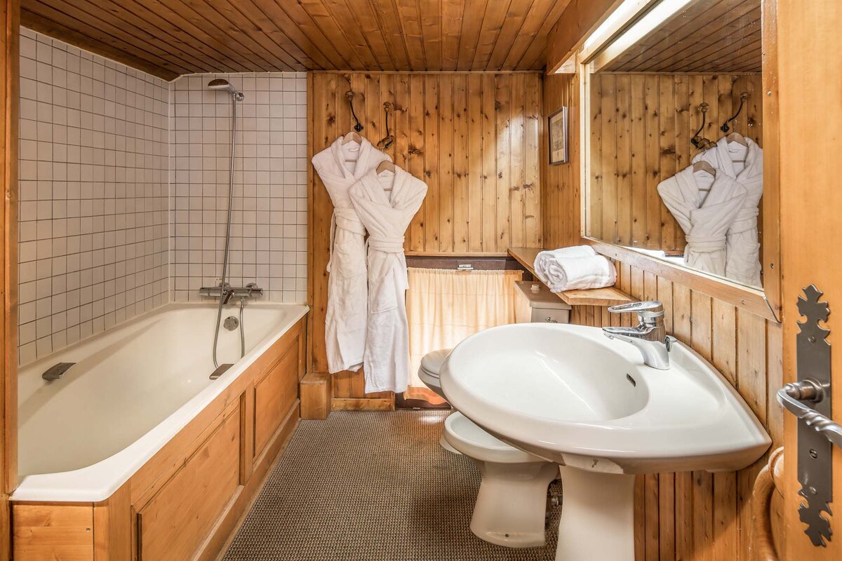 A bathroom with a bathtub sink and mirror