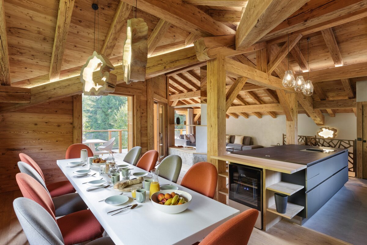 A dining room table with a bowl of fruit on it