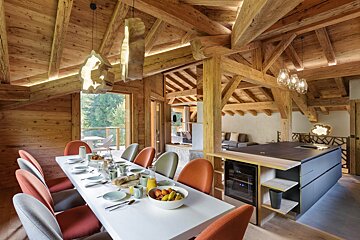 A dining room table with a bowl of fruit on it