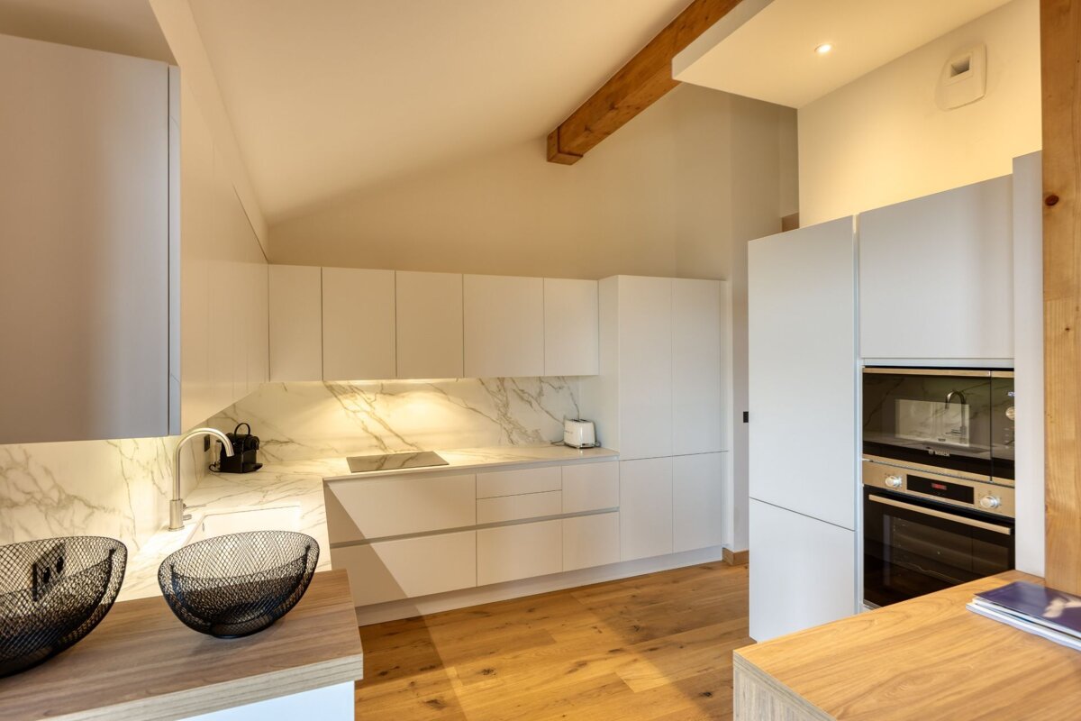 A kitchen with white cabinets and a stainless steel oven
