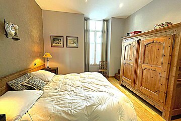 A bedroom with a bed and a picture on the wall