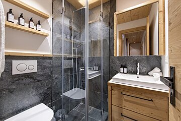 A bathroom with a toilet a sink and a mirror