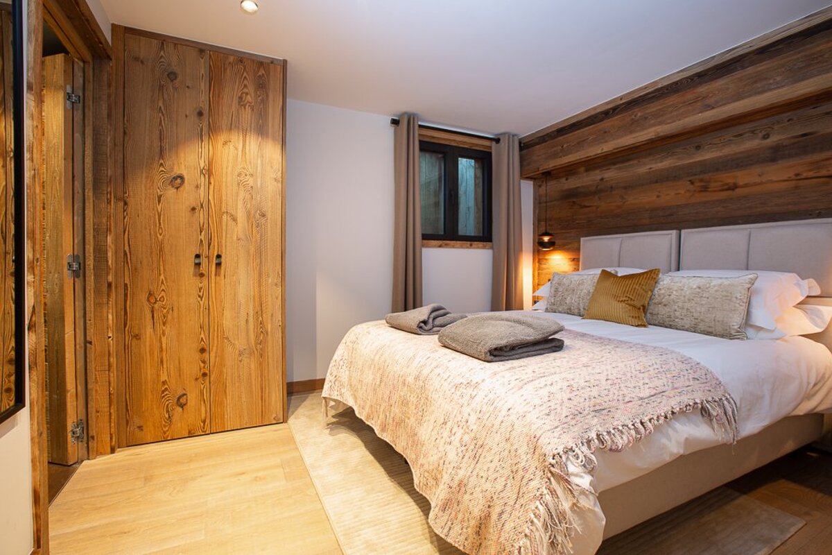 A bedroom with a bed and a wooden wall