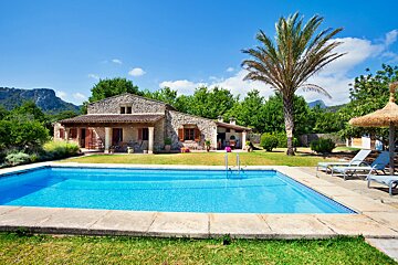 A house with a large swimming pool in front of it