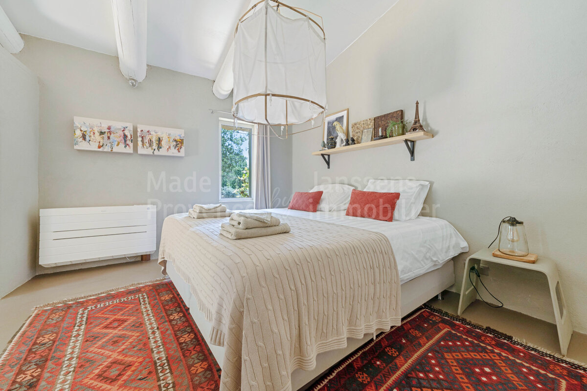 A bedroom with a bed and a rug and a sign that says made