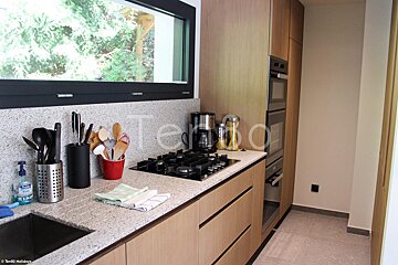 A kitchen with utensils on the counter and the word tempo on the wall
