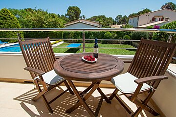 Two chairs and a table with a bottle of wine on it