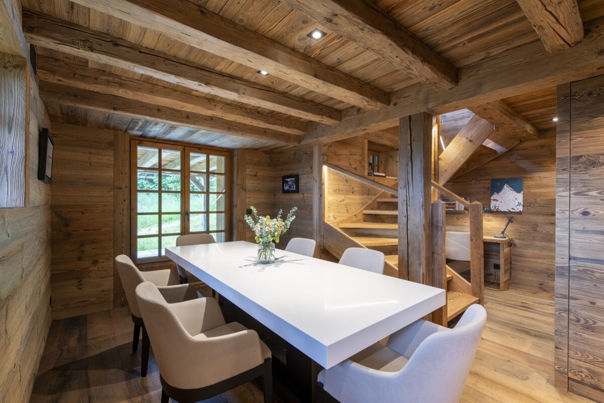 A dining room table with a vase of flowers on it