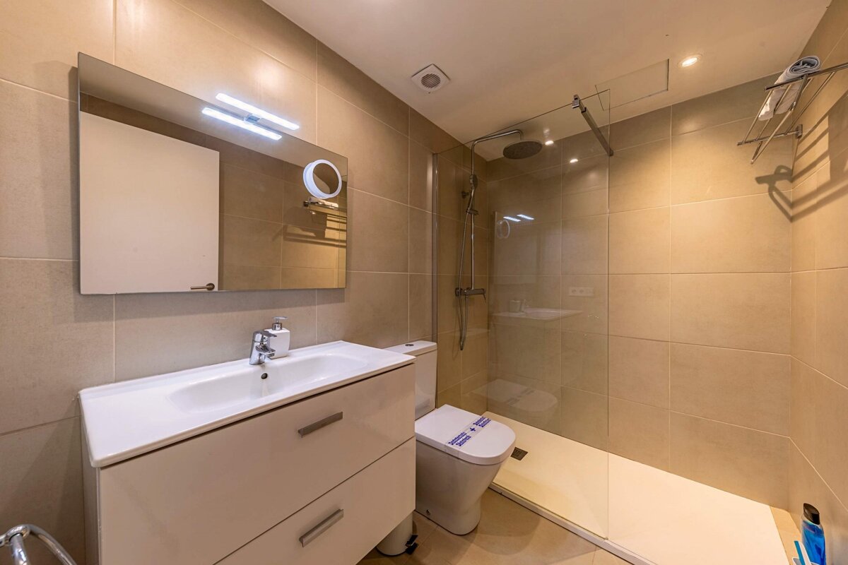 A bathroom with a toilet a sink and a mirror