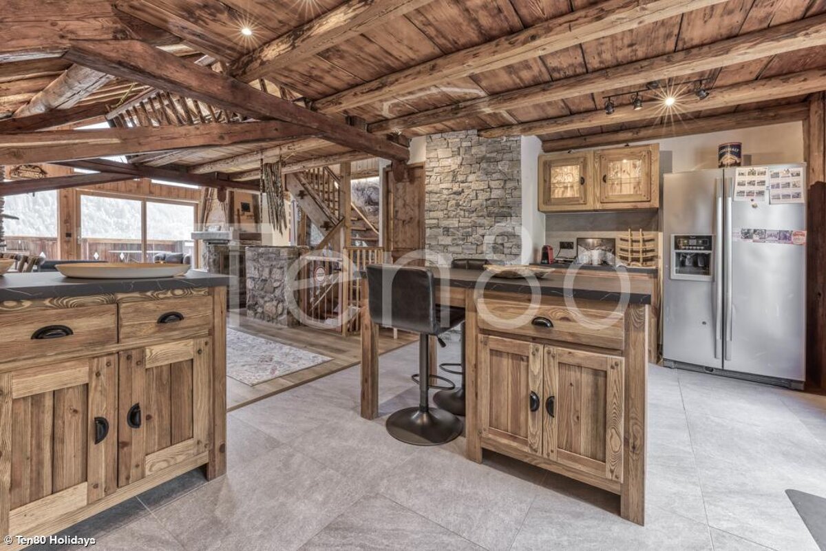 A kitchen with wooden cabinets and a stainless steel refrigerator