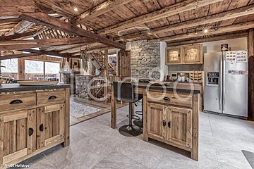 A kitchen with wooden cabinets and a stainless steel refrigerator