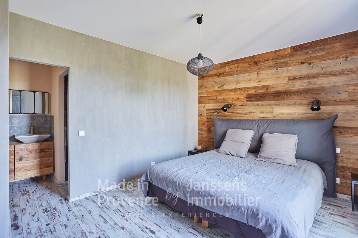 A bedroom with a bed made in provence by immobilier