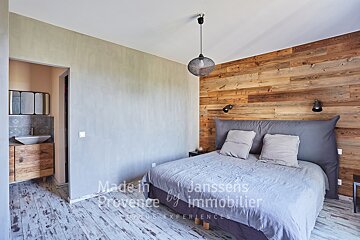 A bedroom with a bed made in provence by immobilier