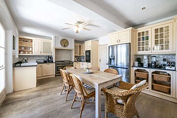 A kitchen with a table and chairs and a clock on the wall