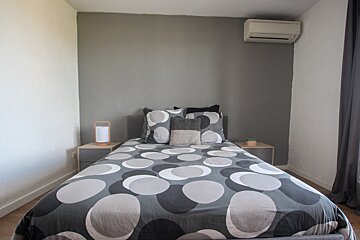 A bed with a polka dot comforter and pillows