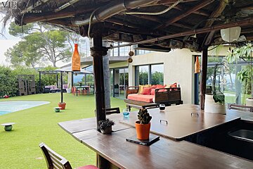 A table and chairs under a thatched roof that says villa