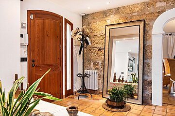 A hallway with a large mirror and a wooden door